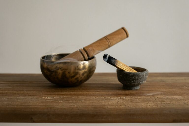 Singing bowl and burning incense on wooden table, ideal for relaxation and meditation