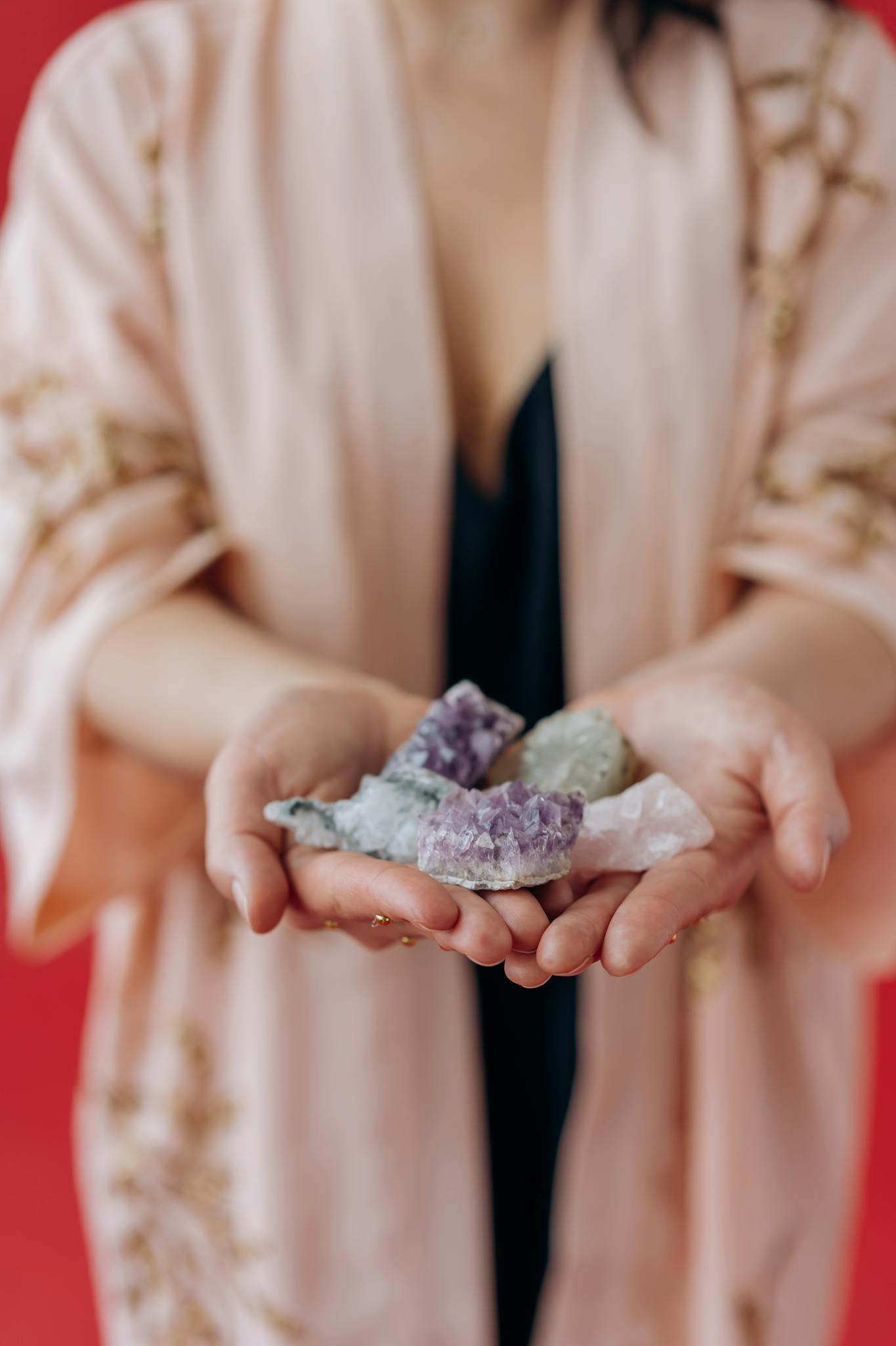 A woman gently holds healing crystals in her hands, focusing on positive energy and mindfulness.
